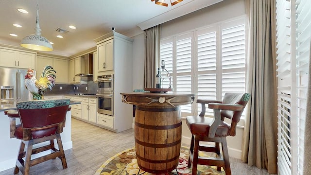 11994 SW Bristol Bay Dr, Port Saint Lucie, FL 34987 - kitchen with decorative backsplash, visible vents, light wood finished floors, wall chimney exhaust hood, and appliances with stainless steel finishes