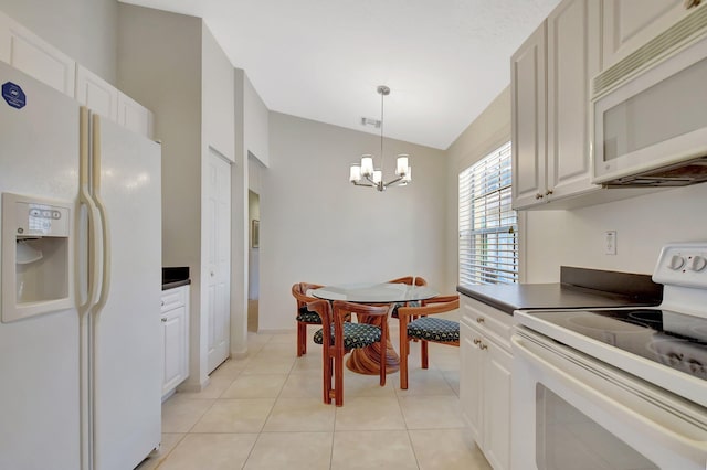 kitchen featuring vaulted ceiling, white appliances, light tile patterned floors, a chandelier, and white cabinets