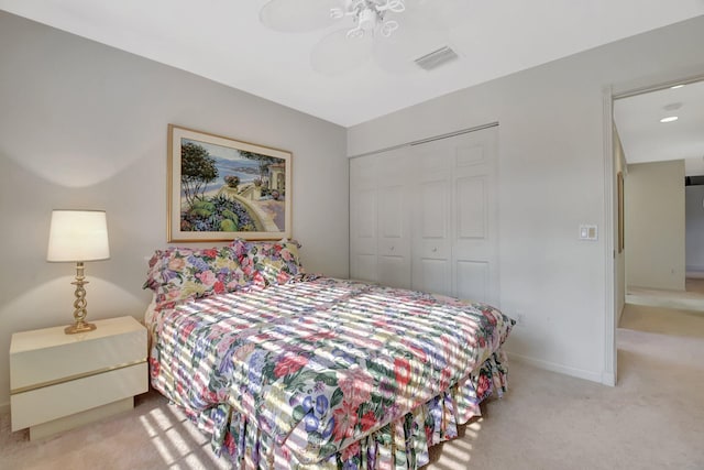 carpeted bedroom with baseboards, visible vents, a closet, and a ceiling fan