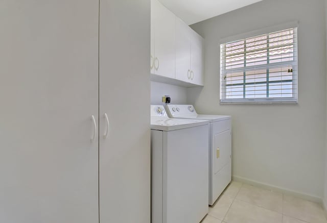 laundry room featuring baseboards, washer and dryer, cabinet space, and light tile patterned floors