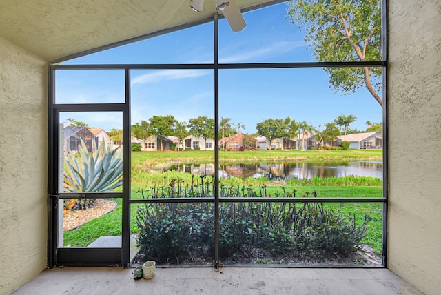 unfurnished sunroom featuring a water view and a residential view