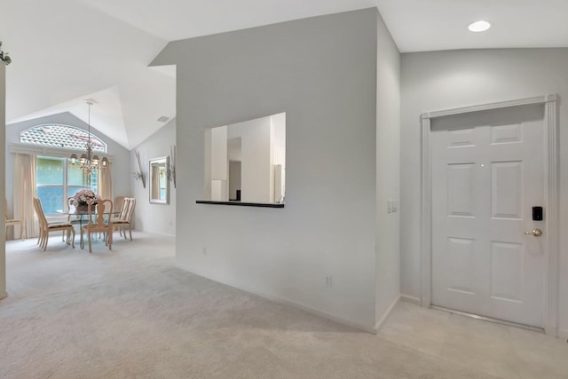 foyer featuring light carpet, a notable chandelier, and lofted ceiling