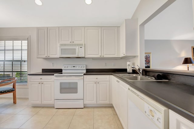kitchen featuring a sink, white cabinetry, light tile patterned floors, white appliances, and dark countertops