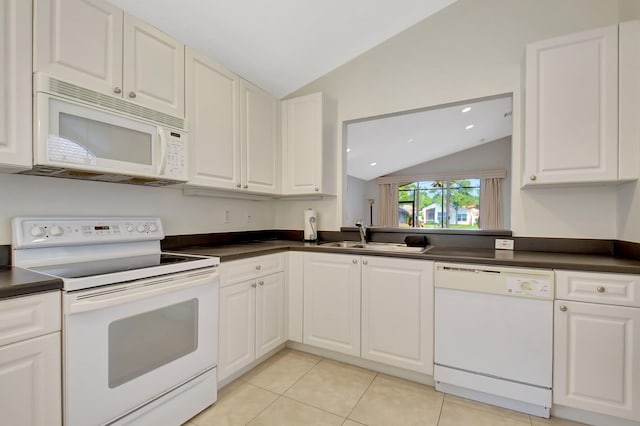 kitchen featuring white appliances, dark countertops, white cabinetry, a sink, and vaulted ceiling