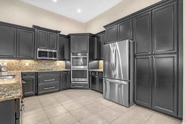 8888 Rockridge Glen Cv, Boynton Beach, FL 33473 - kitchen with tasteful backsplash, light tile patterned floors, stone counters, appliances with stainless steel finishes, and dark cabinets