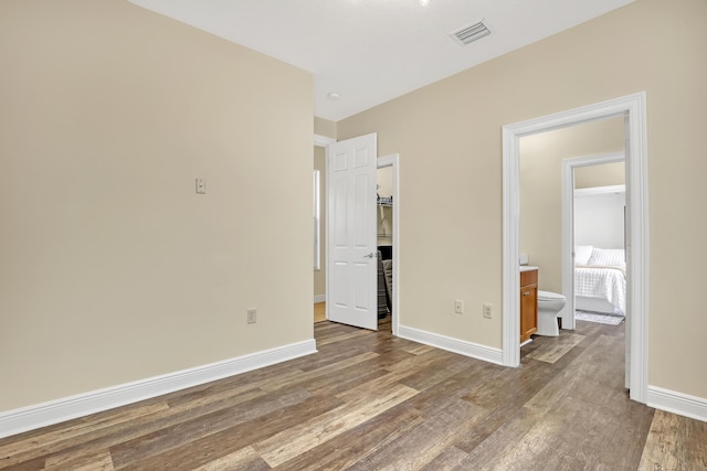 8888 Rockridge Glen Cv, Boynton Beach, FL 33473 - unfurnished bedroom with baseboards, visible vents, a spacious closet, and wood finished floors
