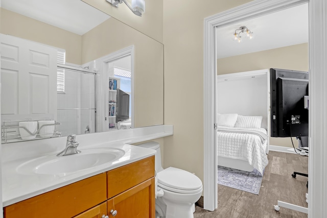 8888 Rockridge Glen Cv, Boynton Beach, FL 33473 - full bathroom featuring connected bathroom, toilet, vanity, wood finished floors, and a shower with shower door
