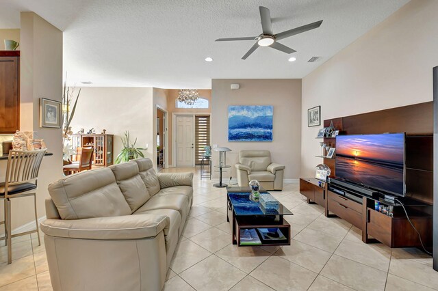 10570 Stone Garden Dr, Boynton Beach, FL 33473 - living room with light tile patterned floors, a textured ceiling, visible vents, and ceiling fan with notable chandelier