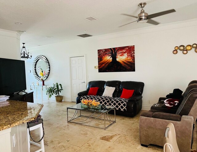 living room with ornamental molding, a ceiling fan, and baseboards