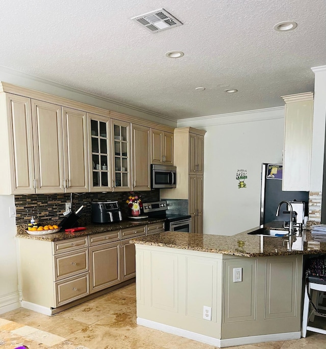 kitchen with stainless steel appliances, glass insert cabinets, decorative backsplash, dark stone countertops, and a peninsula