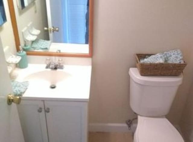 6020 Indrio Rd Unit 6, Fort Pierce, FL 34950 - half bathroom featuring toilet, vanity, and baseboards