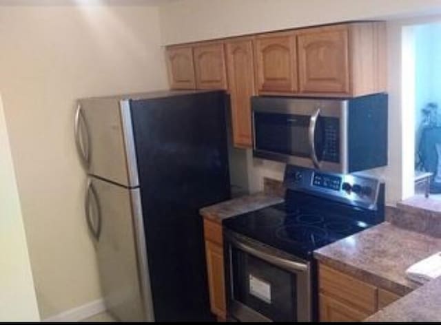 6020 Indrio Rd Unit 6, Fort Pierce, FL 34950 - kitchen featuring baseboards, brown cabinets, and stainless steel appliances