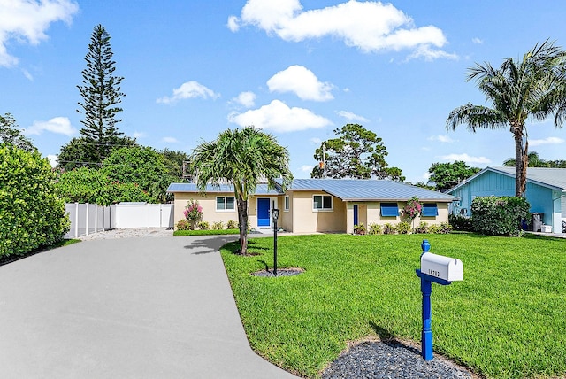 14283 Joan Dr, Palm Beach Gardens, FL 33410 - ranch-style home with stucco siding, a metal roof, driveway, and a standing seam roof