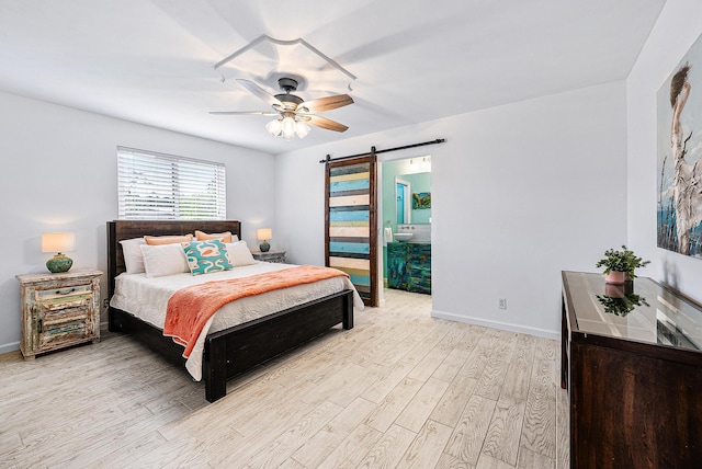 14283 Joan Dr, Palm Beach Gardens, FL 33410 - bedroom featuring a barn door, light wood-style flooring, a ceiling fan, and connected bathroom