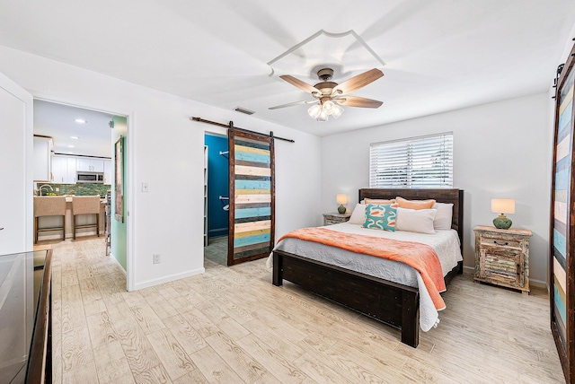 14283 Joan Dr, Palm Beach Gardens, FL 33410 - bedroom featuring a barn door, light wood-style floors, a ceiling fan, and recessed lighting