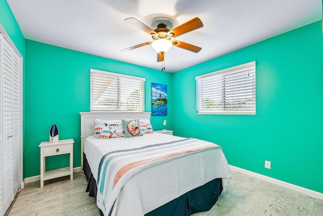14283 Joan Dr, Palm Beach Gardens, FL 33410 - bedroom with multiple windows, wood finished floors, and ceiling fan