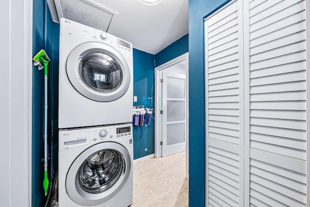 14283 Joan Dr, Palm Beach Gardens, FL 33410 - laundry area featuring estacked washer and dryer and wood finished floors