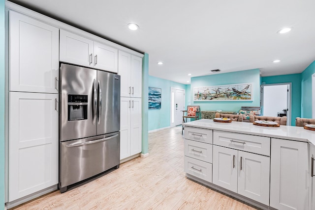 14283 Joan Dr, Palm Beach Gardens, FL 33410 - kitchen featuring stainless steel refrigerator with ice dispenser, light wood-style floors, light countertops, open floor plan, and recessed lighting
