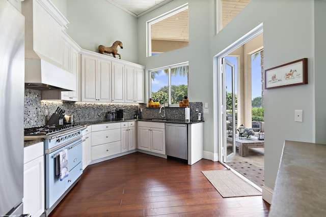 2990 Twin Oaks Way, Wellington, FL 33414 - kitchen with appliances with stainless steel finishes, a sink, dark wood finished floors, white cabinetry, and backsplash