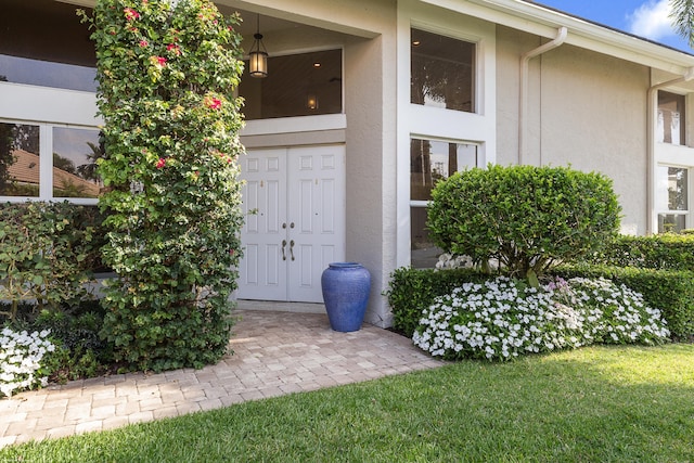 2990 Twin Oaks Way, Wellington, FL 33414 - view of exterior entry with a lawn and stucco siding