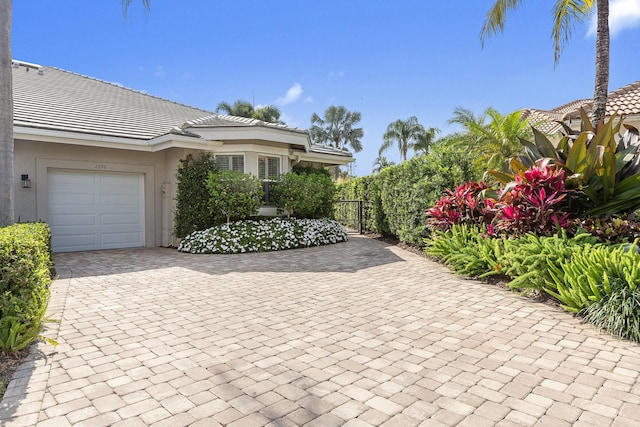 2990 Twin Oaks Way, Wellington, FL 33414 - exterior space with a tiled roof, decorative driveway, fence, an attached garage, and stucco siding