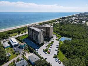 drone / aerial view with a water view and a view of the beach