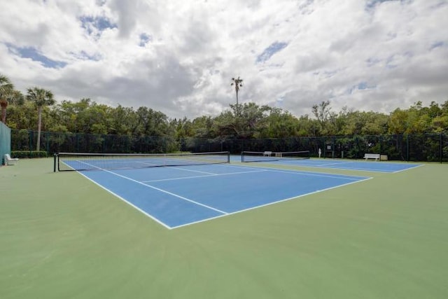 view of tennis court featuring fence and community basketball court