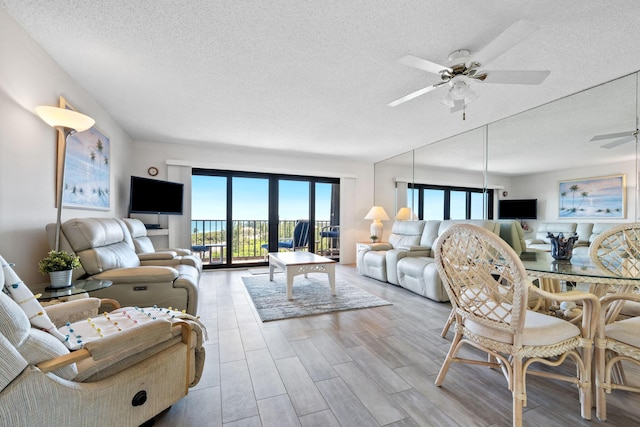 living area featuring a textured ceiling, wood finished floors, and a ceiling fan