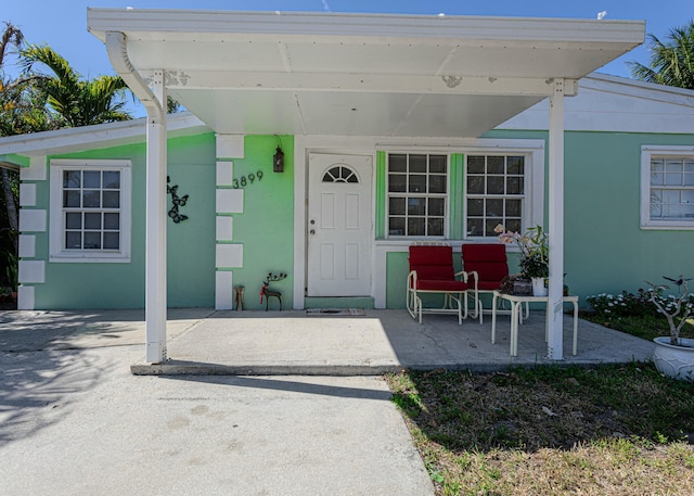 3899 Tuskegee Dr, Lake Worth, FL 33462 - doorway to property with stucco siding and a porch