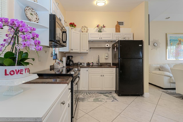 3899 Tuskegee Dr, Lake Worth, FL 33462 - kitchen featuring black appliances, a sink, light tile patterned flooring, and white cabinets