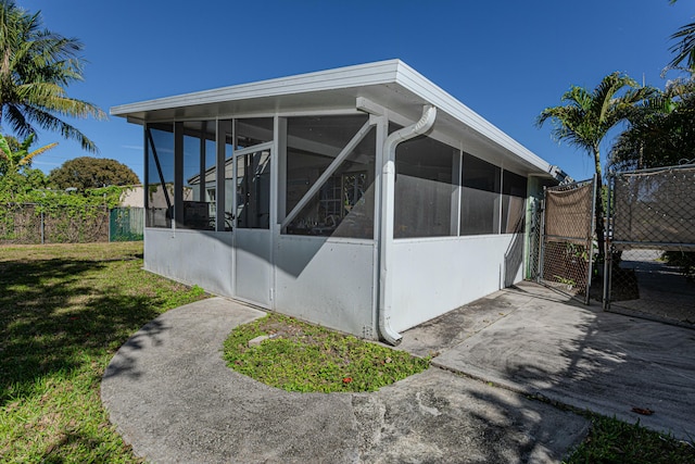 3899 Tuskegee Dr, Lake Worth, FL 33462 - view of side of property with a sunroom and a gate