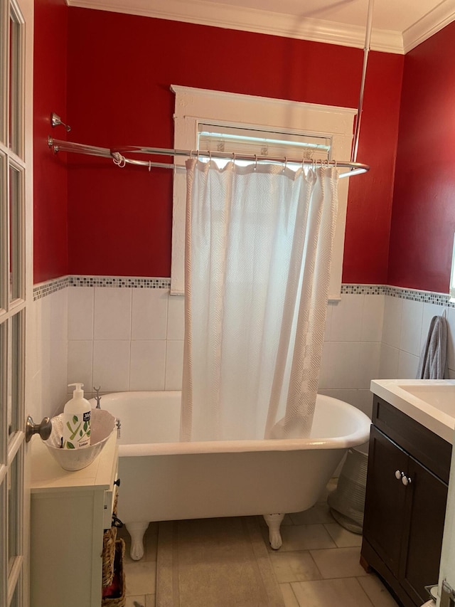 220 Malverne Rd, West Palm Beach, FL 33405 - full bathroom featuring tile patterned floors, a wainscoted wall, tile walls, vanity, and ornamental molding