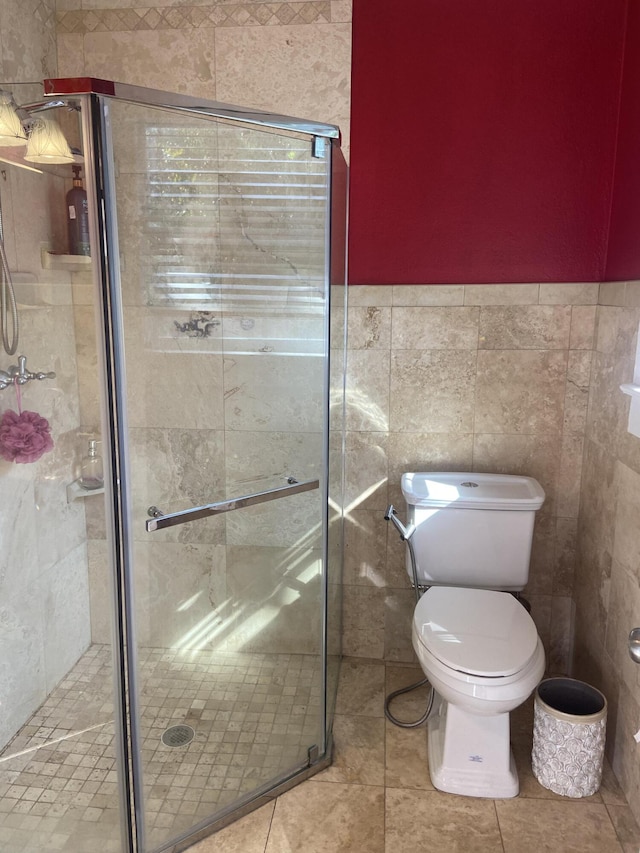 220 Malverne Rd, West Palm Beach, FL 33405 - full bathroom featuring tile walls, tile patterned flooring, a shower stall, and toilet