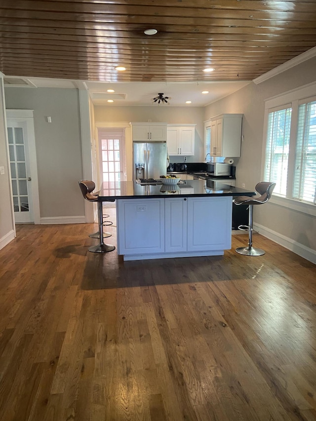 220 Malverne Rd, West Palm Beach, FL 33405 - kitchen featuring stainless steel fridge with ice dispenser, dark countertops, a kitchen breakfast bar, and a healthy amount of sunlight
