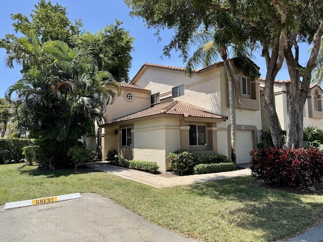 mediterranean / spanish-style house featuring stucco siding, a tile roof, uncovered parking, and a front yard