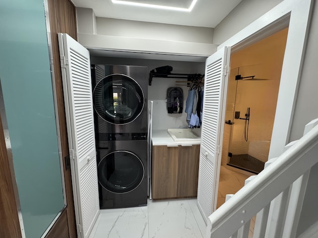 laundry area featuring marble finish floor, stacked washer / dryer, and laundry area