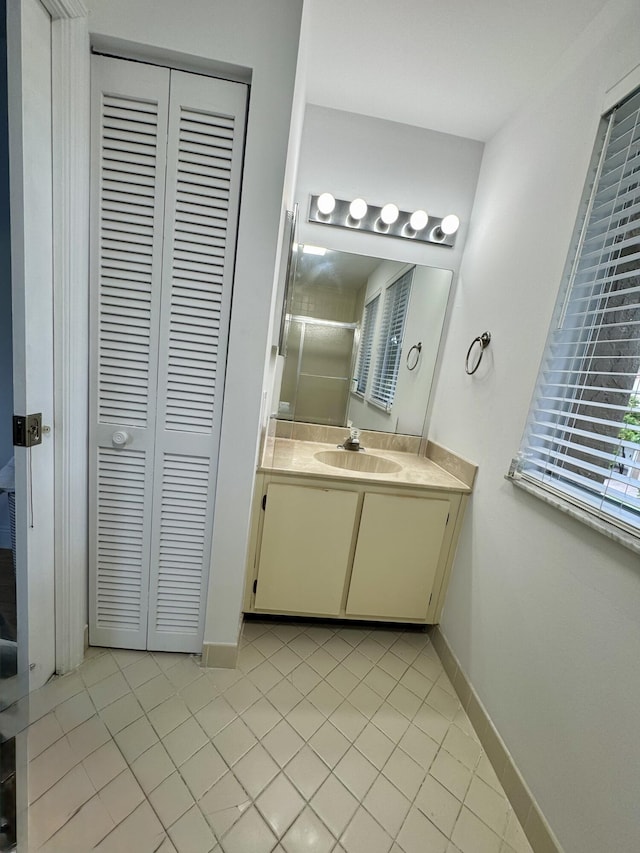 bathroom with baseboards, tile patterned flooring, and a closet