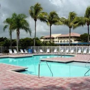 community pool with a patio and fence