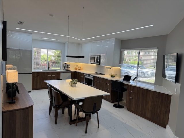 kitchen with modern cabinets, visible vents, a sink, and stainless steel appliances