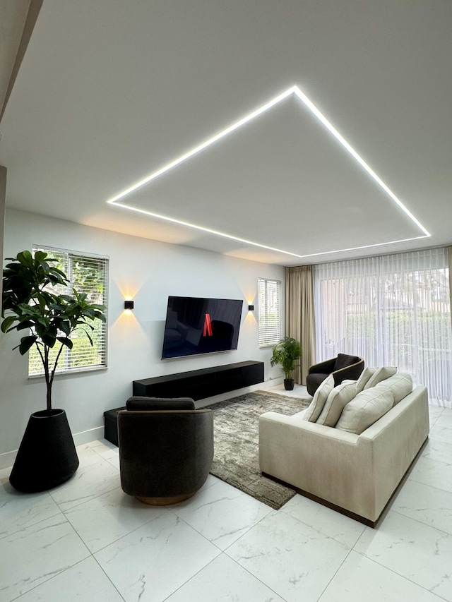living area featuring baseboards and marble finish floor