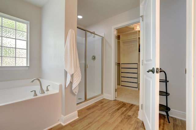 134 Day Dr, Sebastian, FL 32958 - full bathroom with a stall shower, a garden tub, wood finished floors, a walk in closet, and baseboards