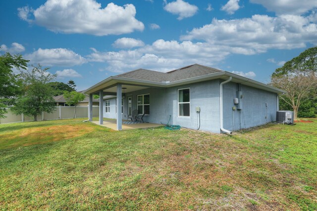 134 Day Dr, Sebastian, FL 32958 - rear view of house with fence, central air condition unit, a patio area, a lawn, and concrete block siding