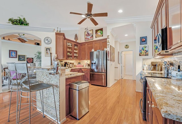 8328 Grand Messina Cir, Boynton Beach, FL 33472 - kitchen with a kitchen bar, appliances with stainless steel finishes, a peninsula, brown cabinets, and ceiling fan