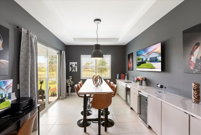dining area featuring a tray ceiling, a wealth of natural light, wine cooler, and light tile patterned floors