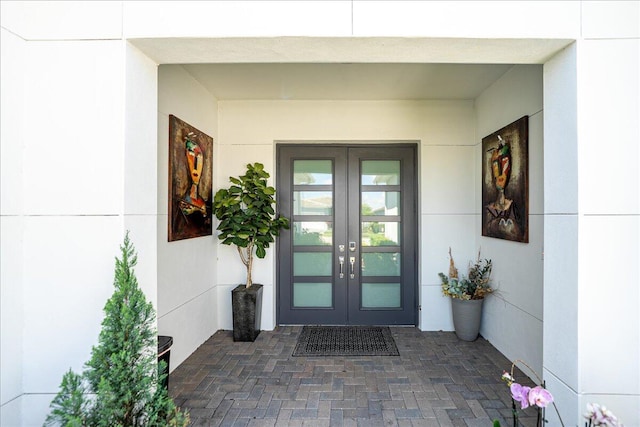 entrance to property featuring french doors and stucco siding
