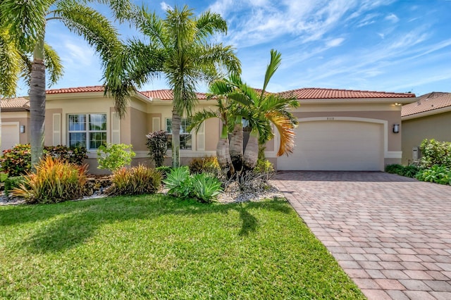 8318 Cameron Cave Dr, Boynton Beach, FL 33473 - mediterranean / spanish home with driveway, a garage, a tile roof, a front lawn, and stucco siding