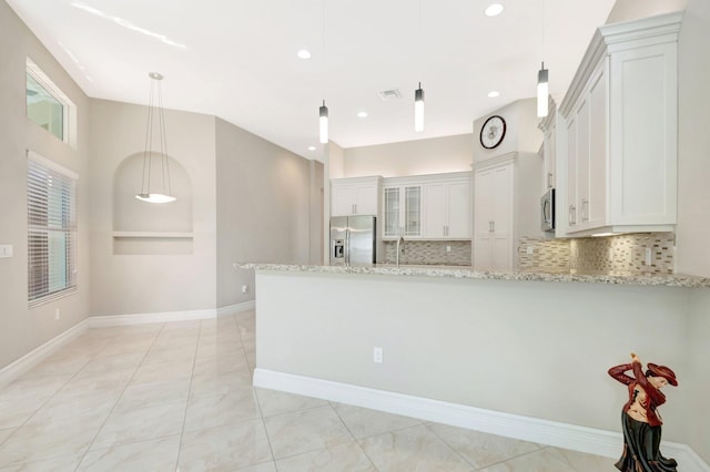 8318 Cameron Cave Dr, Boynton Beach, FL 33473 - kitchen featuring white cabinetry, tasteful backsplash, stainless steel appliances, light stone countertops, and a peninsula