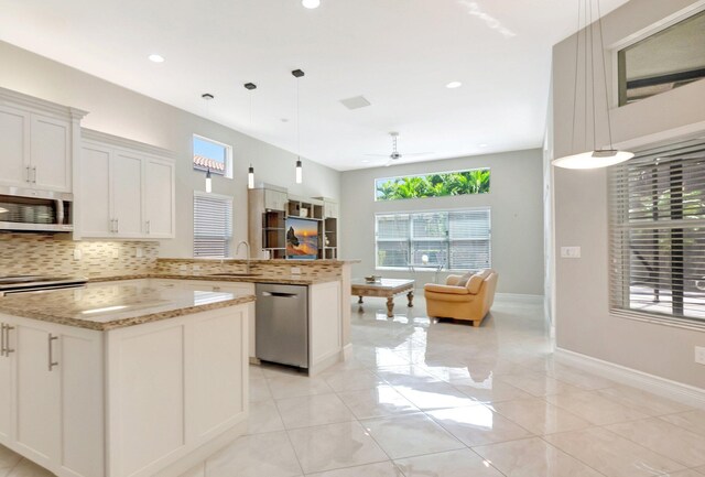 8318 Cameron Cave Dr, Boynton Beach, FL 33473 - kitchen featuring a sink, backsplash, appliances with stainless steel finishes, a peninsula, and open floor plan