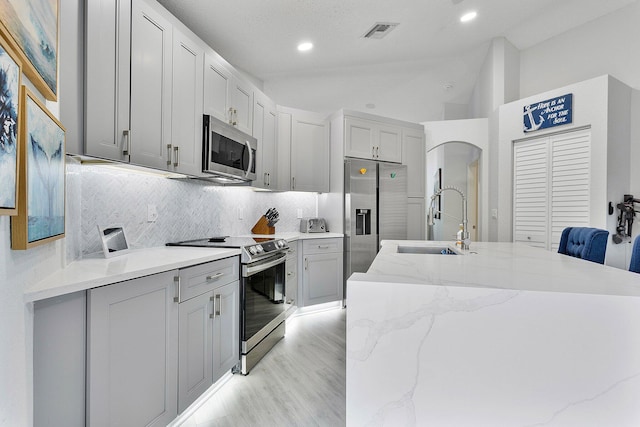 3773 NW 63rd Ct, Coconut Creek, FL 33073 - kitchen with visible vents, stainless steel appliances, tasteful backsplash, lofted ceiling, and a sink