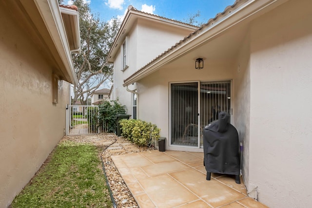 3773 NW 63rd Ct, Coconut Creek, FL 33073 - view of exterior entry featuring stucco siding, a gate, and a patio area
